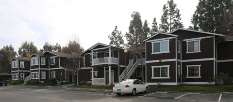 a row of houses with a car parked in a parking lot